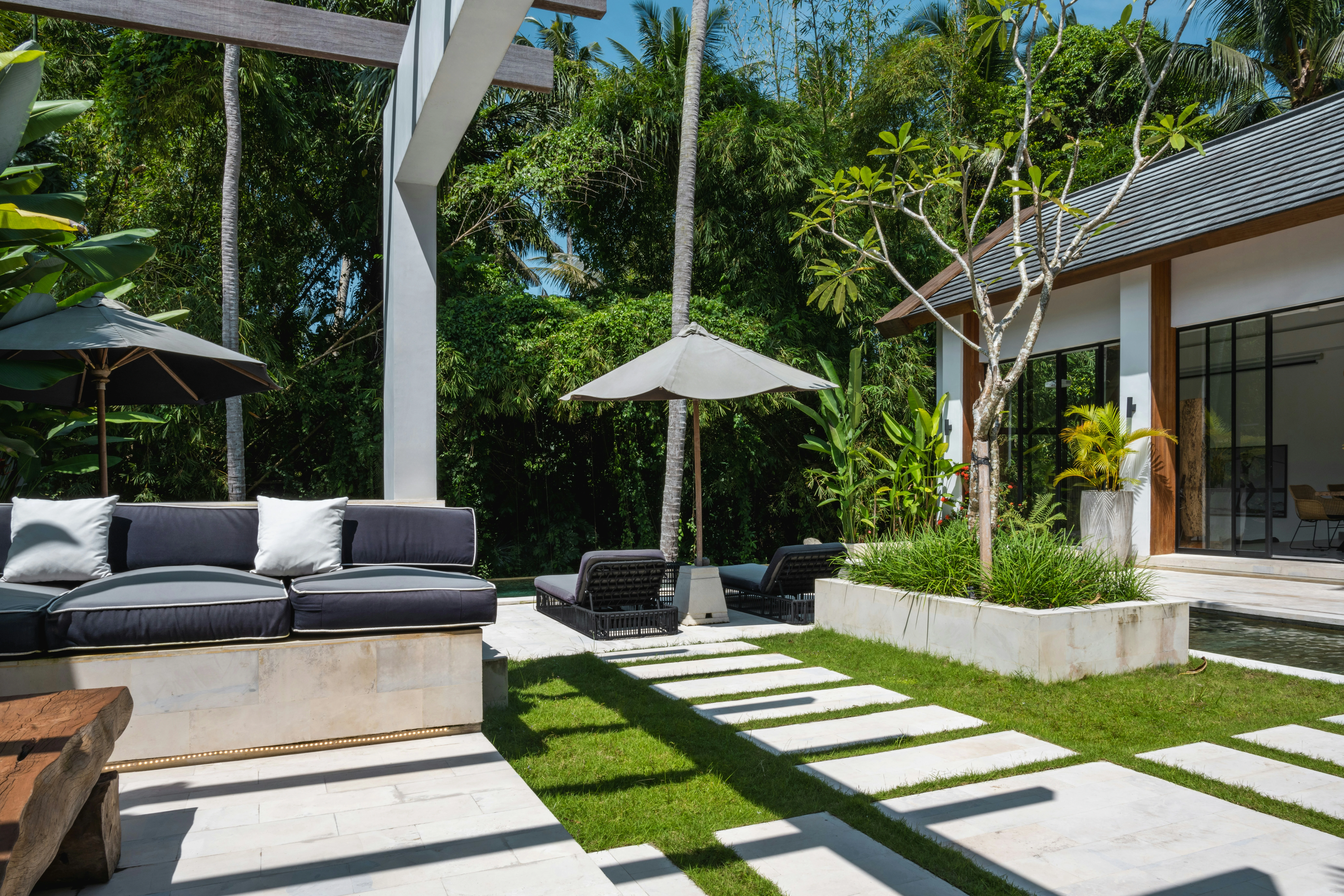 Projet frange urbaine — patio moderne avec banquette outdoor, parasol et dalles minérales